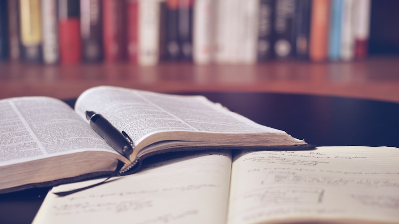 Mesa de estudo com livros e laptop para escrita acadêmica